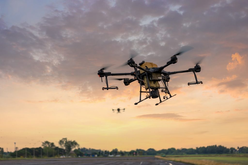 Modern smart farm with drone. Agriculture drone fly to Ready spray fertilizer on the rice fields.